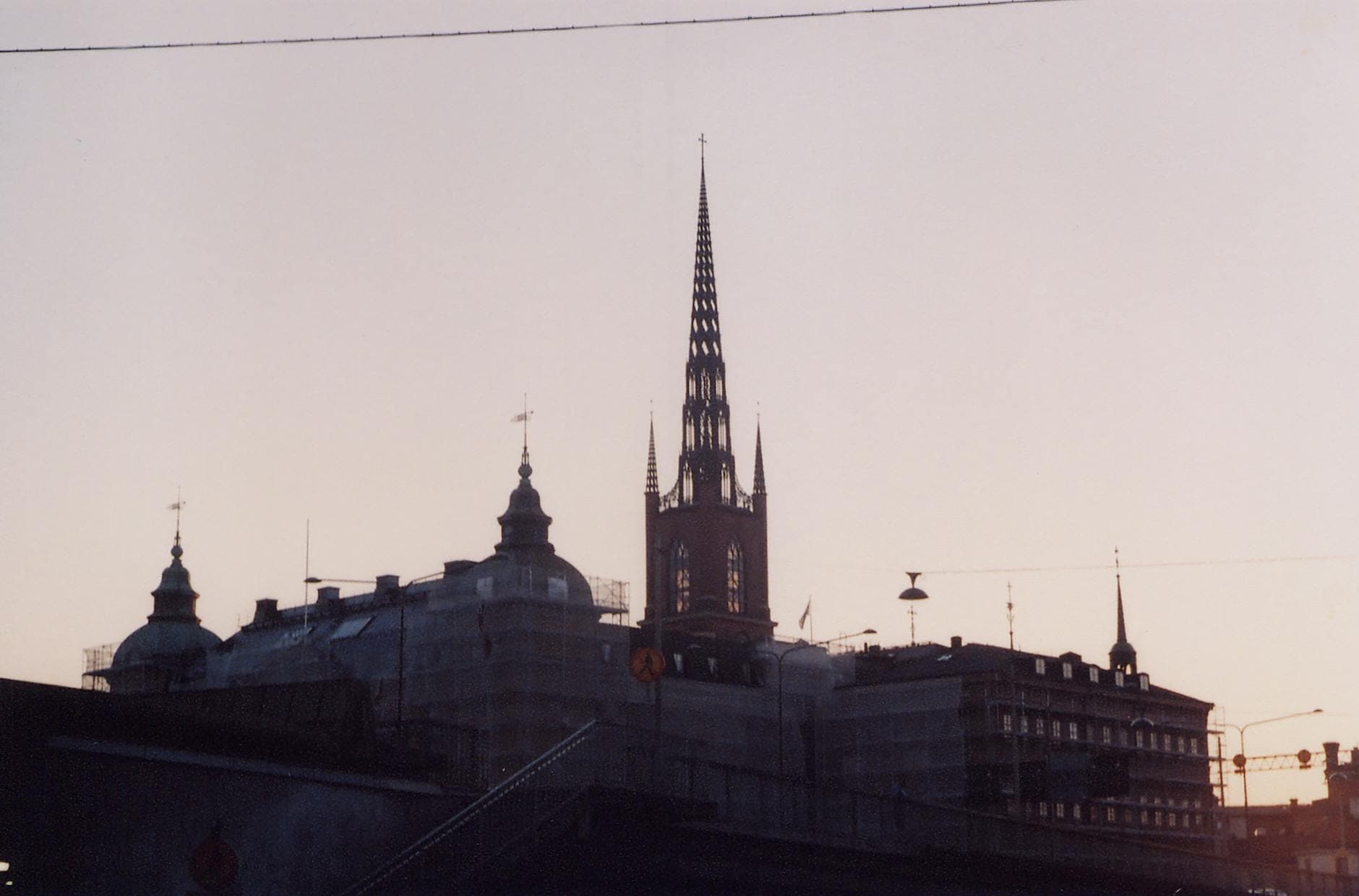 Silhouette of Riddarholmen Church in Stockholm during sunrise creates a dramatic Gothic skyline.