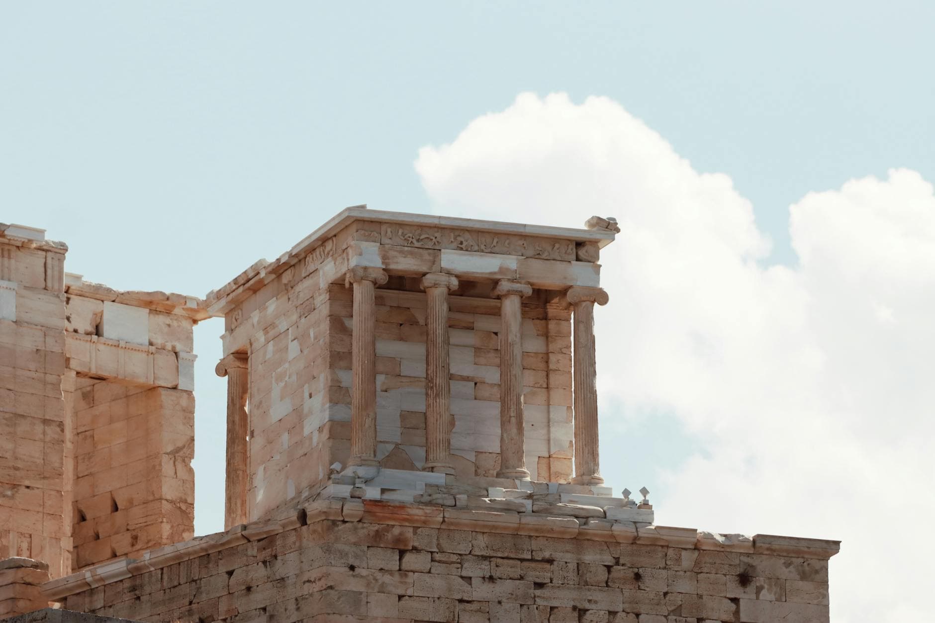Close-up of ancient temple ruins in the Acropolis of Athens under a clear sky.