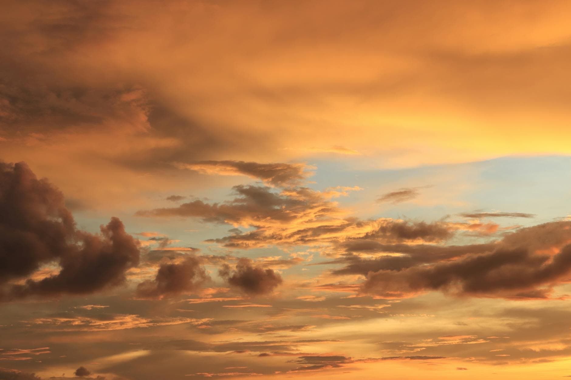 A breathtaking view of dramatic golden clouds during sunset with a serene sky.