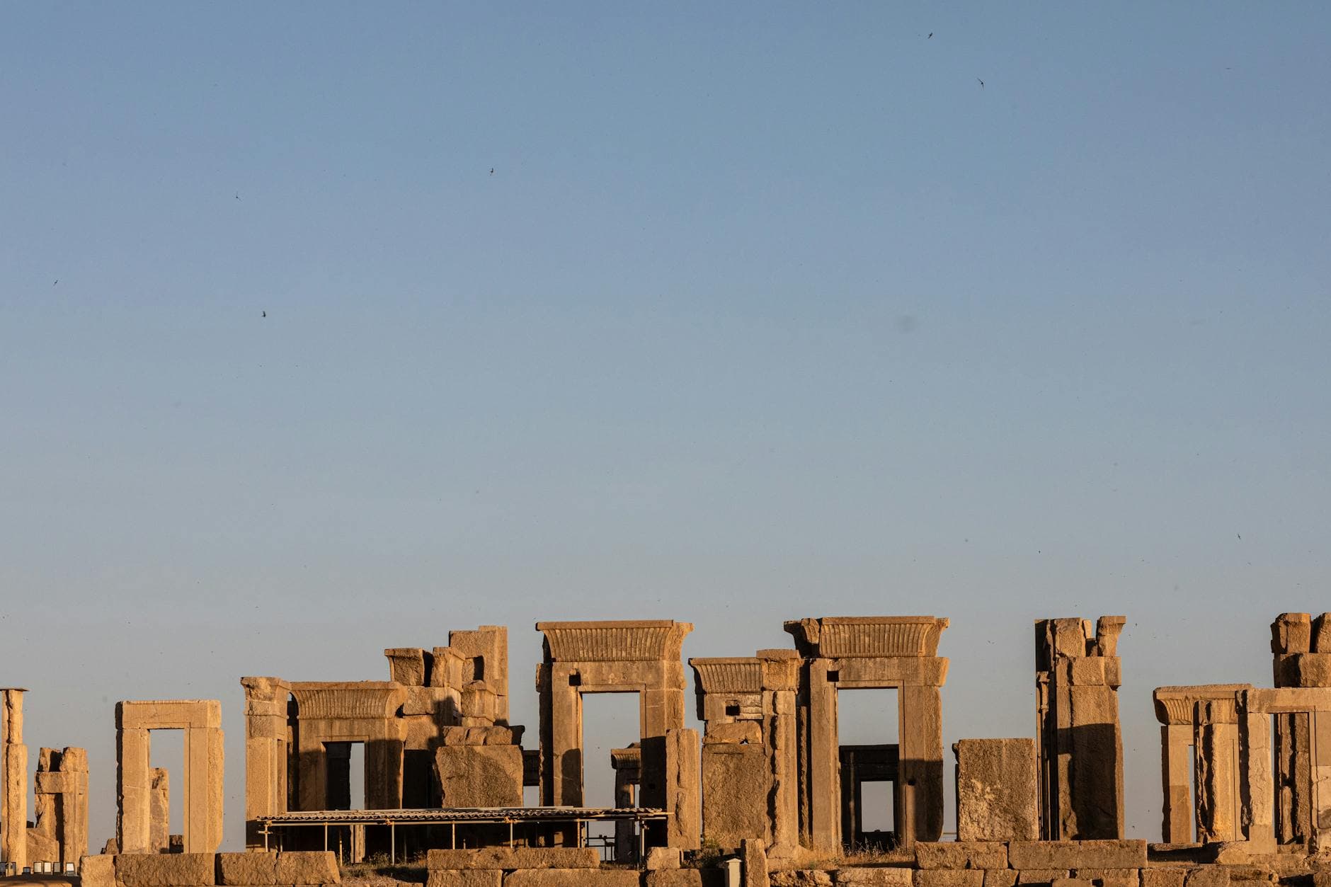 Explore the majestic Apadana ruins of Persepolis under a clear blue sky, showcasing Persian architecture.